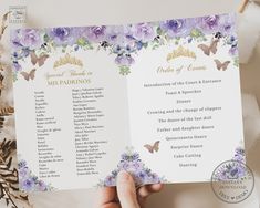 a person holding up a wedding program with purple flowers and butterflies on the front cover