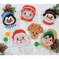 cross stitch santa and snowman lollipop toppers on a white brick wall