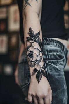 a woman's arm with flowers on it, and her hand in the middle