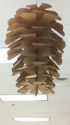 a wooden light fixture hanging from the ceiling in an office building with white walls and ceilings