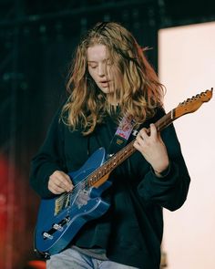 a woman playing an electric guitar on stage