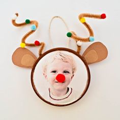 a child's christmas ornament with a red nose and reindeer antlers