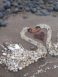 a heart made out of rocks on the beach