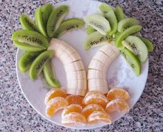 a plate topped with sliced kiwis and oranges on top of a counter