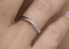 a woman's hand with a diamond ring on her left side and the other half of her finger