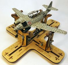 an old model airplane sitting on top of a wooden stand with two planes attached to it