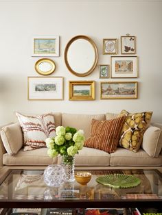 a living room filled with furniture and pictures on the wall