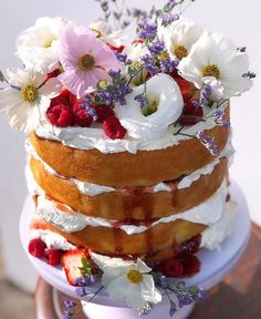 the cake is decorated with flowers and berries