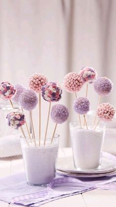 small vases filled with pink and purple flowers on a table cloth covered tablecloth