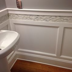 a white sink sitting next to a toilet in a bathroom on top of a hard wood floor