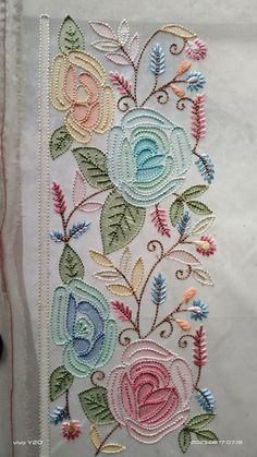 an embroidered piece of cloth with flowers on it