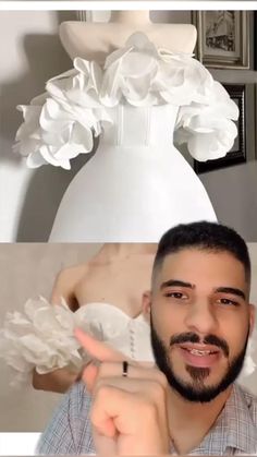 a man pointing at a white dress with flowers on it