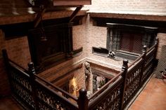 an old fireplace in the corner of a room with brick walls and iron railings