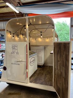 the inside of a trailer with lights and wood flooring