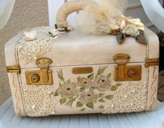 an old suitcase is decorated with flowers and feathers