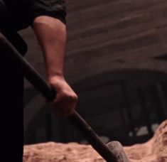 a man is shoveling sand with a large hammer