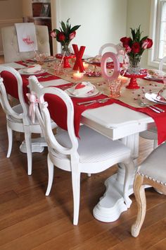 the table is set for valentine's day with flowers and candles