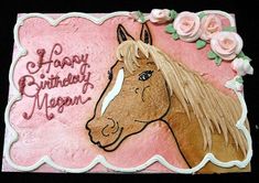 a pink birthday cake with a horse on it's face and flowers around the edges