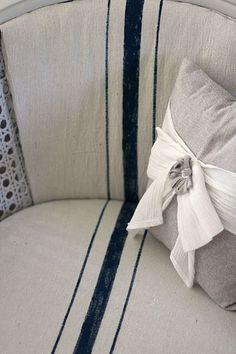 a close up of a cushion on a chair with blue and white striped fabric around it