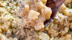 a wooden spoon scooping some food out of a casserole dish