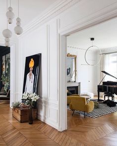 a living room filled with furniture and a painting on the wall above a piano keyboard