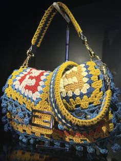 a crocheted purse is displayed on a black surface with a mirror in the background