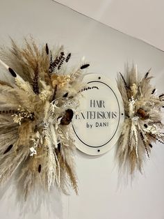 there are two fake feathers on the wall next to each other in front of a sign that says hair extensions by dani