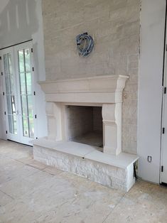 a fireplace in the middle of a room with white walls and doors on both sides