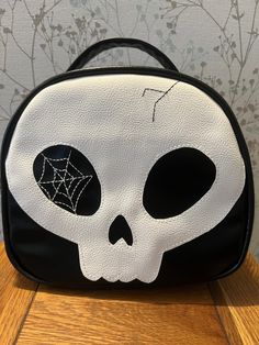 Skull bag ( carbon chic design) with long adjustable strap. The bag is made from vegan friendly faux leather and cotton liner. This is soft yet holds it's shape. The double zip pull on the top is an excellent addition. Bag zip pocket and an internal zip pocket gives you lots of secure spaces. This bag also has some lovely metal feet to save the bottom of your bag from wear and tear. The size is approximately 22cm tall by 23 cm wide and 10 cm deep. It's a cute bag. I will be making more that's fo Black Zipper Closure Shoulder Bag For Halloween, Black Skull Bag For Halloween, Black Skull-shaped Bag For Halloween, Black Skull Print Bag For Halloween, Black Halloween Bag With Skull Print, Black Halloween Bags With Skull Print, Halloween Skull Print Travel Bag, Black Skull-shaped Bag With Skull Print, Dulceros Halloween