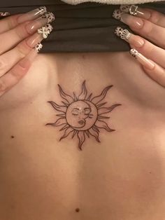 a woman's stomach with a sun and moon tattoo on her chest, showing the back