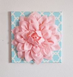 a pink flower on a blue and white wall