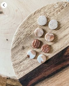 four different types of cookies on a wooden board with white and brown circles around them