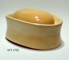 a wooden bowl sitting on top of a white table