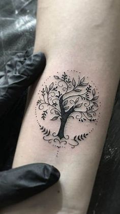 a small tree tattoo on the right arm and leg, with leaves around it's branches