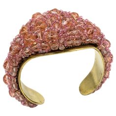 Coppola and Toppo designed this fabulous rare cuff bracelet in the 1950s. The bracelet boasts a brass framing and is ornate with multi-strands of beads brought together to form a striking intricate design. As with all of their necklaces and bracelets, the row of beads appears to have been made from a single, taut thread. This construction creates a subtle and elegant twist, belying its true complexity and creating this unusual, flowing design. The clear powder pink and salmon pink multifaceted crystal beads absorb and reflect the light beautifully. The signature on the underside reads made in Italy by Coppola e Toppo. The bracelet is in good condition, with minor wear on the metal framing, but it does not significantly affect the overall appearance of a piece of this age. Measurements: ins Mid-century Bangle Bracelets As Gifts, Mid-century Bangle Bracelet For Gift, Evening Jubilee Cuff Bracelet Bangle, Vintage Beaded Bangle Bracelets For Party, Vintage Cuff Bracelets For Parties, Vintage Cuff Bracelet For Party, Vintage Bangle Cuff Bracelet For Evening, Vintage Bangle Cuff Bracelet For Party, Vintage Evening Bangle Cuff Bracelet