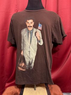 Vintage Borat Movie Tee - Rare  - Y2K vintage  - Movie promo licensed  - Borat graphic  - Borat tagged ripple junction  - Double stitched  Size: XL  29" shoulder to waist 23" armpit to armpit  Good vintage condition No rips or holes  No stains 90s Cotton T-shirt With Front Print, Vintage Cotton Shirt For Fan Merchandise, Brown Cotton Top With Graphic Design, Retro Short Sleeve Shirt With Front Print, Brown Vintage T-shirt For Streetwear, Cotton Pop Culture Tops With Sublimation Print, Pop Culture Cotton Shirt With Graphic Print, Vintage Shirt With Graphic Print For Fans, Vintage Graphic Print Shirt For Fans