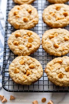 peanut butter oatmeal cookies cooling on a wire rack, with one cookie in the middle