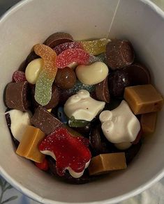 a white bowl filled with lots of different types of candies