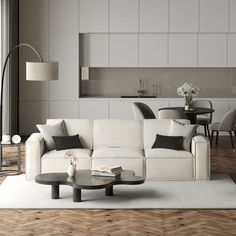 a living room filled with furniture and a white rug on top of a hard wood floor