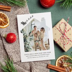 a christmas card with an image of two people on it next to oranges and cinnamon sticks