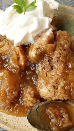 a close up of a plate of food with ice cream on top and sauce in the middle