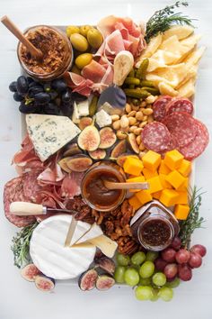 a platter filled with different types of cheeses and fruits