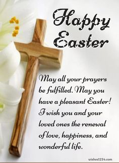 a wooden cross sitting on top of a white flower next to a paper with the words happy