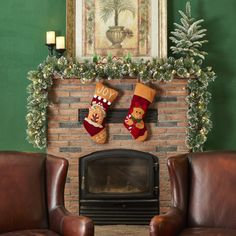 two brown leather chairs sitting in front of a fireplace with stockings hanging from the mantle