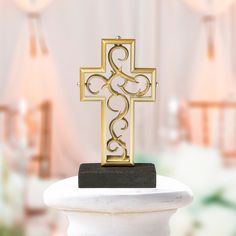 a golden cross on top of a white pedestal