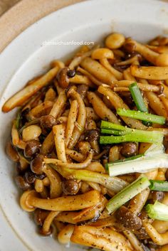 a white plate topped with noodles and mushrooms