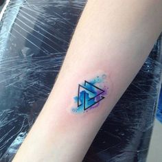 a small blue triangle tattoo on the left forearm and right arm, with an instagram logo