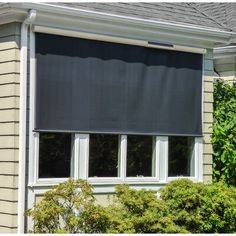 an image of a window with blinds on the side of it in front of a house