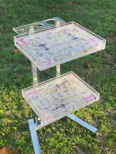 a three - tiered tray is sitting in the grass