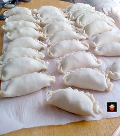 some dumplings are sitting on a piece of paper and ready to be cooked in the oven